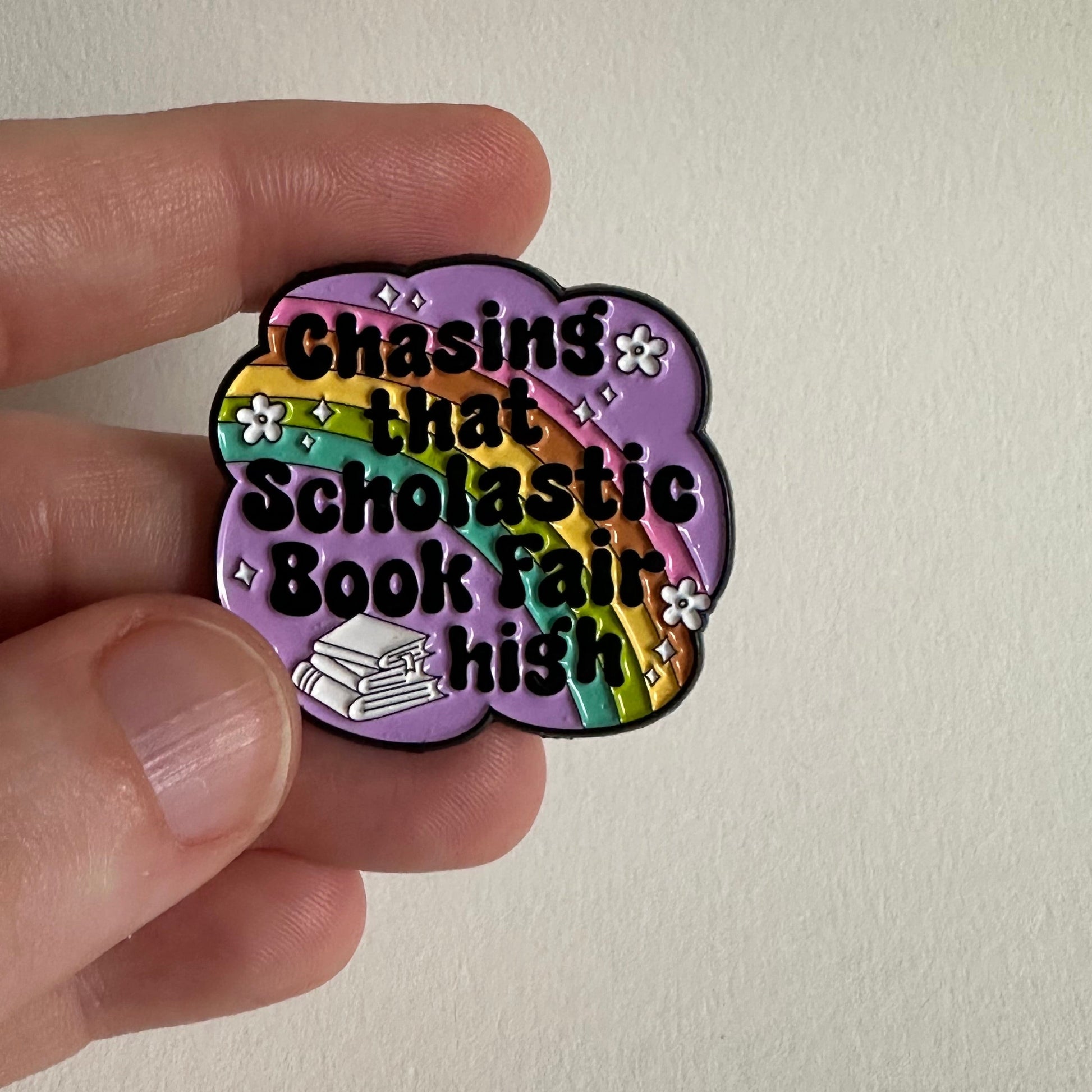 Chasing That Scholastic Book Fair High Enamel Pin, 1.3” x 1.3” - Merry May